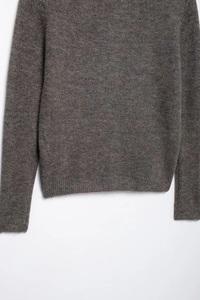 Detailaufnahme von grauem Strickpullover mit weicher Textur und Rippbündchen