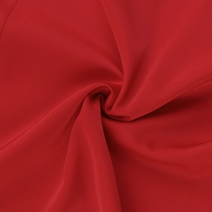 Macro shot of red satin dress fabric showing smooth texture and elegant drape folds