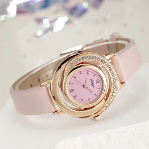Close-up of pink leather watch with sparkling rhinestone bezel and golden quartz dial