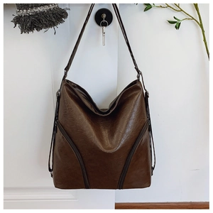 Detail of vintage brown PU leather shoulder bag featuring symmetrical zipper design