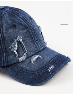 Close-up of vintage distressed denim baseball cap with frayed holes and curved brim