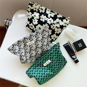 Detailed shot of three floral printed cotton makeup bags with elegant zipper closure