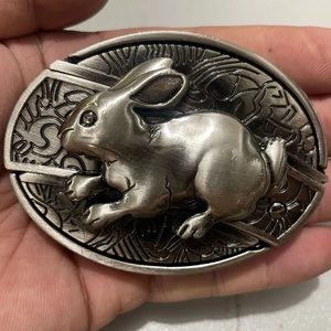 Close-up of vintage alloy belt buckle with 3D embossed rabbit and playboy engraving