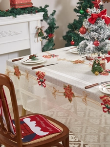 Close-up of Christmas tablecloth featuring poinsettia embroidery and bow details