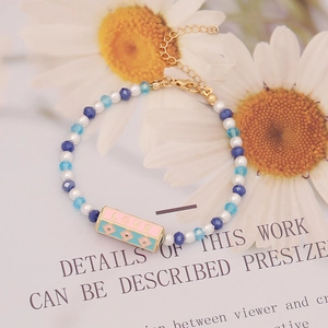Detail of crystal bead bracelet with pink LOVE charm and adjustable golden clasp