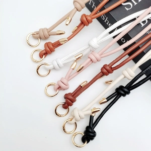 Multiple colorful leather bag straps with knot detail and golden metal ring hardware