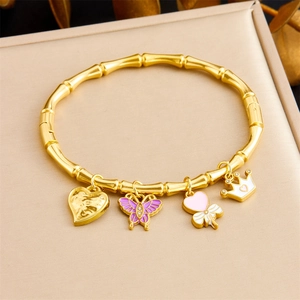 Gold bamboo-style stainless steel bracelet featuring heart, butterfly, and crown charms