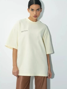 Λεπτομέρεια από κρεμ λευκό oversized βαμβακερό t-shirt με μινιμαλιστική στάμπα με γράμματα