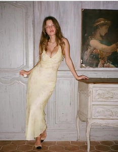 Détail d'une robe longue en soie jaune pâle à fleurs avec bords à volants
