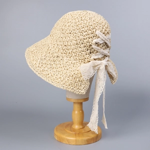 Detail of woven straw texture and delicate lace bow on an elegant summer sun hat