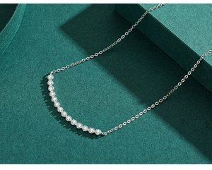 Macro view of sterling silver bar necklace with curved row of sparkling cubic zirconia