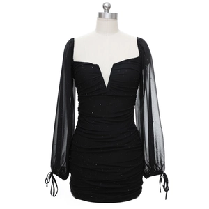 Détail des manches longues en mesh avec paillettes sur robe noire moulante col V