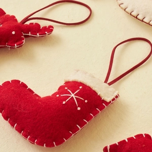 Christmas felt ornaments featuring red and white stocking and reindeer with hanging string