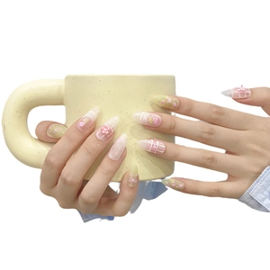 Pink coquette press-on nails with 3D bows and floral patterns on almond-shaped tips