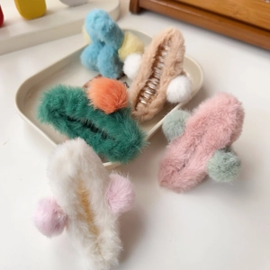 Detail of plush faux fur hair clips in assorted colors on a neutral display tray