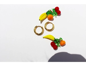 Detailed close-up of 18K gold plated hoop earrings with glass fruit charms in vibrant colors