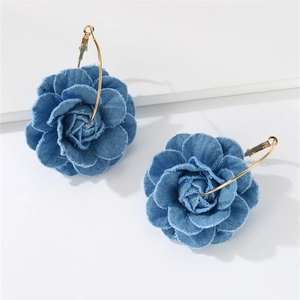 Macro detail of blue denim camellia flower petals and gold circular earring hooks