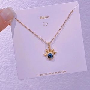 Dettaglio della collana pianeta stella dorata con pietra blu su cartoncino