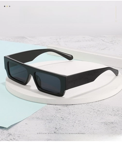 Close-up of black square frame sunglasses on a minimalist white circular display stand