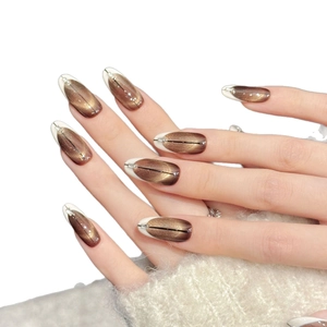 Caramel brown cat eye press-on nails with silver trim and rhinestone accents