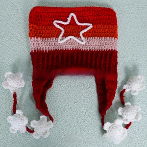 Detail of hand-knitted cat ear hat featuring colorful stripes and white crochet stars