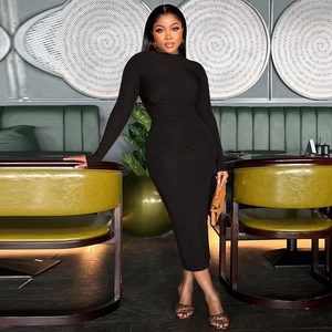 Detail of black slim-fit long sleeve midi dress with ruched waist in restaurant setting