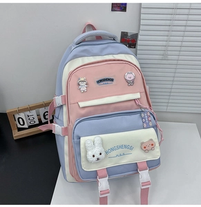 Detail of multi-compartment student backpack with cute cartoon badges and charms
