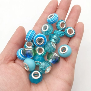 Close-up of blue crystal glass beads and DIY jewelry charms held in hand for children