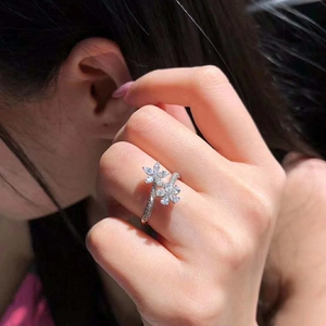 Sparkling silver flower open ring with teardrop zircons on a model's hand