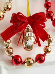 Dettaglio del fiocco di velluto rosso e guanto dorato per decorazione ghirlanda natale