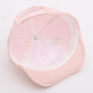 Detail view of pink corduroy baby hat interior with metal rivet and adjustable strap