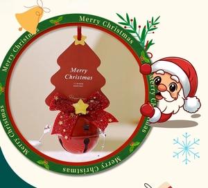Detail of red metal bell with star cutouts and festive glitter bow on tree card
