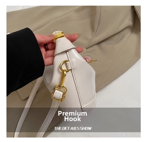Detail of durable gold-tone metal hooks on white shiny faux leather children handbag