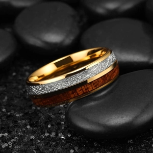 Detail of 8mm gold men's ring with wood inlay and textured surface on black stones