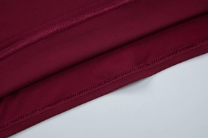 Vue macro de l'ourlet en tricot bordeaux avec des détails de couture à double aiguille