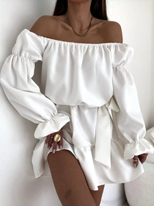 Détail de robe blanche à épaules dénudées avec satin brillant et poignets à volants et ceinture