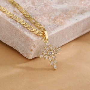 Gold-plated cross pendant necklace with zircon stones on a beige natural stone base