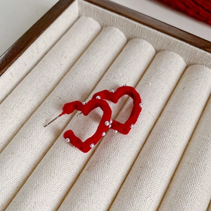 Détail de boucle d'oreille cœur rouge floqué avec perles sur une boîte à bijoux luxe