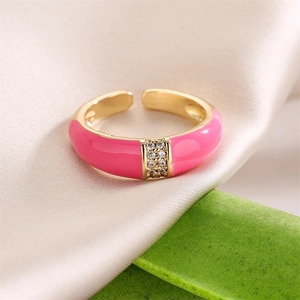Detail of 18K gold ring featuring pink enamel finish and shimmering zircon stones inlay