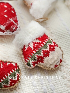 Close-up of knit Christmas ornaments featuring red gloves and hearts with faux fur trim