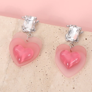 Detail of pink triple heart earrings with lace ribbon style and crystal accents