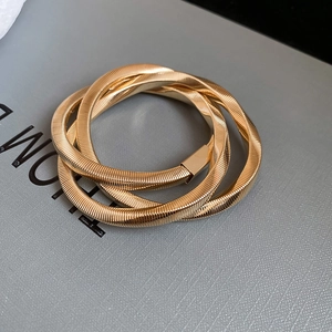 Detailed macro view of the gold coiled snake chain bracelet with textured metallic screw pattern
