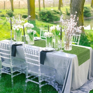 Close-up of a realistic green artificial grass table runner on a wedding dinner table