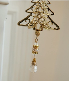 Detailed view of golden metal Christmas tree ornament with elegant faceted crystal drop