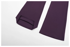 Detail of dark purple flared yoga pants showing flatlock stitching and stretch fabric texture