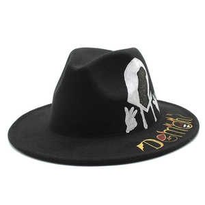 Black wool fedora hat with white hooded figure print and yellow Demon embroidery