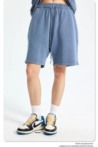 Detail of blue cotton sweat shorts featuring elastic drawstring waist and knit texture
