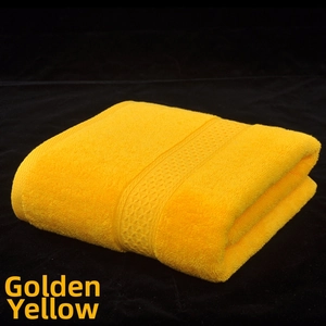 Detail of golden yellow cotton towel featuring intricate honeycomb weave edges