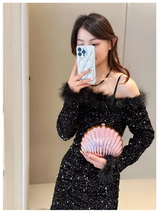 Pink pearlescent shell-shaped clutch bag featuring textured radial ribs and a rigid frame