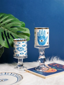 Detail of Hamsa hand and evil eye ceramic mugs with elegant gold rims and blue patterns